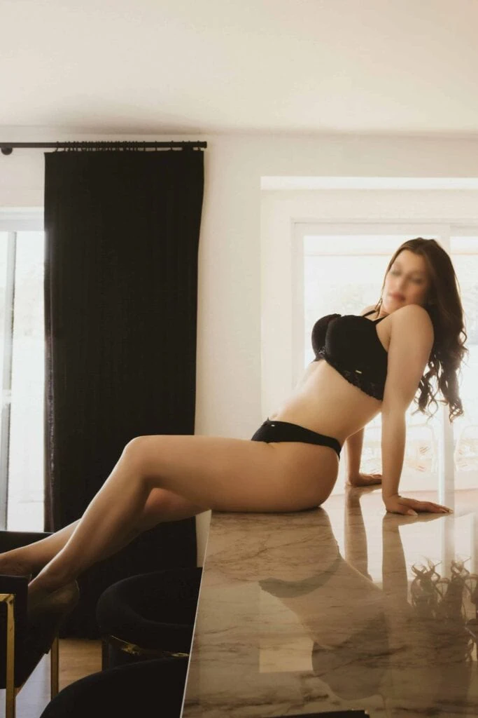Ava Marie is posing in elegant lingerie on a glossy marble table inside a room bathed in natural light. Ava Marie Halifax's Elite Independent Companion